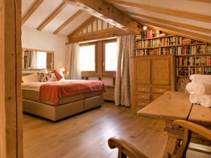 a bedroom with a bed and a book shelf at Apartment Chesa Misaun by Interhome in Pontresina
