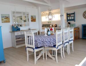 Baby Whale Bliss - Beachfront House في ويستاند: غرفة طعام مع طاولة وكراسي ومطبخ