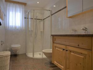 uma casa de banho com um chuveiro, um WC e um lavatório. em Apartment Chesa Dal Luf B5 by Interhome em Silvaplana