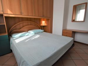 a bedroom with a large bed with a wooden headboard at Holiday Home Mediterraneo by Interhome in Rosapineta