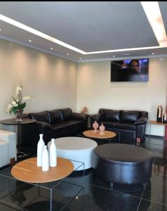 a lobby with couches and tables and a tv at Hotel Center Vitoria in Vitória de Santo Antão