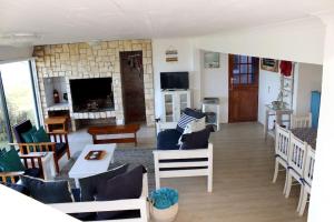 Baby Whale Bliss - Beachfront House في ويستاند: غرفة معيشة مليئة بالأثاث ومدفأة
