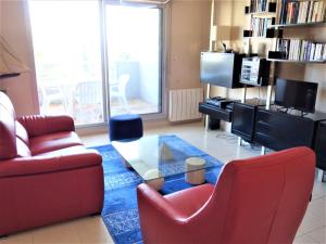 salon z czerwoną kanapą i szklanym stołem w obiekcie Apartment Terrasses d'Emeraude-1 by Interhome w mieście Dinard