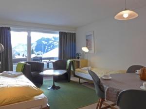 ヴェンゲンにあるApartment Residence by Interhomeのベッド、テーブル、椅子が備わるホテルルームです。