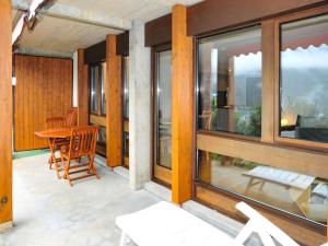 eine Veranda mit einem Tisch, Stühlen und Fenstern in der Unterkunft Studio Krokus by Interhome in Wengen