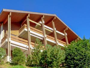 um edifício de madeira com árvores em frente em Studio Krokus by Interhome em Wengen