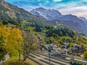 a small town in the mountains with a train at Apartment Eiger Residence Apt-A-425 by Interhome in Wengen