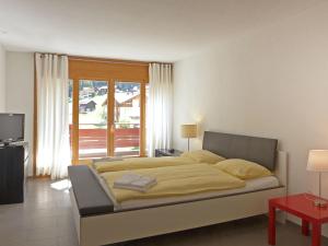 A bed or beds in a room at Apartment Eiger Residence Apt-H by Interhome