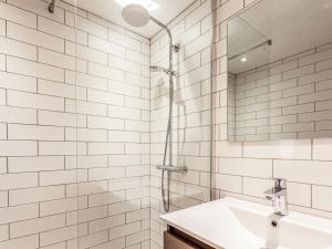 a white tiled bathroom with a sink and a shower at Apartment Les Grets-9 by Interhome in Saint-Gervais-les-Bains