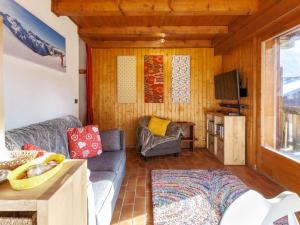 a living room with a couch and a tv at Apartment Les Grets-9 by Interhome in Saint-Gervais-les-Bains