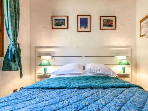a bedroom with a blue bed with two lamps at Apartment Les Grets-9 by Interhome in Saint-Gervais-les-Bains +20 photos