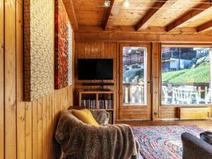 a living room with a tv and a chair in a room at Apartment Les Grets-9 by Interhome in Saint-Gervais-les-Bains