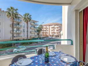 uma mesa com copos e uma garrafa de vinho na varanda em Apartment L'Open-11 by Interhome em Fréjus