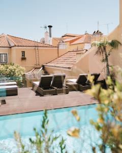 uma vista para uma piscina com cadeiras e uma casa em Palacio Ramalhete em Lisboa