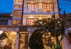 a large white building with a lot of windows at Laramani Hotel Boutique in Cusco