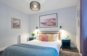 a bedroom with a large bed with two blue tables at Ness Central in Inverness