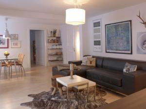 ein Wohnzimmer mit einem schwarzen Sofa und einem Tisch in der Unterkunft Apartment Bristol-2 by Interhome in Wengen