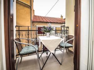 einen Tisch und Stühle auf einem Balkon mit einer Blumenvase in der Unterkunft Apartment Snježana-1 by Interhome in Karlobag
