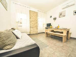 ein Wohnzimmer mit einem Tisch und einem Schreibtisch in der Unterkunft Apartment Snježana-1 by Interhome in Karlobag