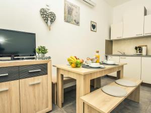 eine Küche mit einem kleinen Tisch und einem TV in der Unterkunft Apartment Snježana-1 by Interhome in Karlobag