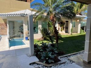una casa con una palmera y una piscina en Casa espetacular em Geribá búzios, en Macapá