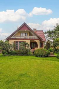 a house with a green lawn in front of it at Holiday Home Letniskowa 29 by Interhome in Ogonki