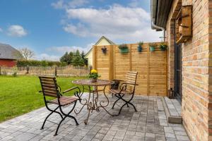 a patio with a table and chairs and a fence at Landhaus 1884 OFC 17 in Beiershagen