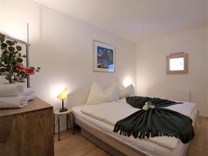 una camera da letto con un letto con un vestito nero sopra di Apartment Chesa Lej by Interhome a Pontresina