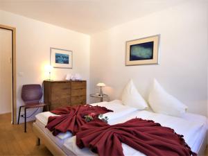 una camera da letto con un letto con una coperta rossa sopra di Apartment Chesa Lej by Interhome a Pontresina