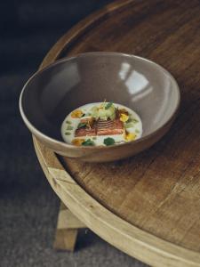 a bowl of food sitting on a wooden table at Boutique hotel Vila Planinka in Zgornje Jezersko
