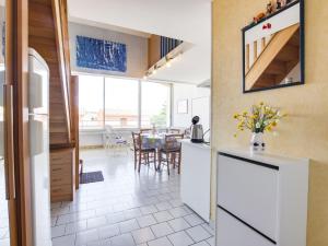 a kitchen with white cabinets and a dining room at Apartment Le Florid-7 by Interhome in Cap d'Agde