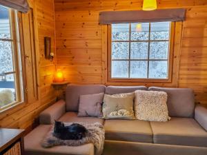 a cat sitting on a couch in a cabin at Holiday Home Willa klaara by Interhome in Patajoki