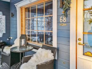 a front porch of a blue house with a table and chairs at Holiday Home Willa klaara by Interhome in Patajoki