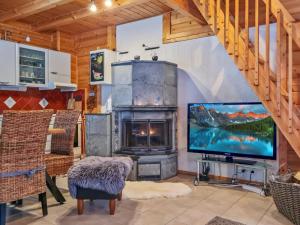 a living room with a fireplace and a tv at Holiday Home Willa klaara by Interhome in Patajoki