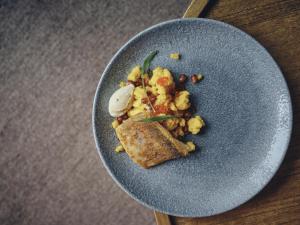 a blue plate with a piece of food on a table at Boutique hotel Vila Planinka in Zgornje Jezersko