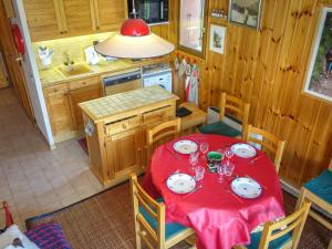 サン・ジェルヴェ・レ・バンにあるApartment La Coupe de Cristal by Interhomeの赤いテーブルと皿付きのキッチンが備わります。