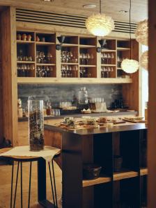 a bar with two stools and a counter with food at Boutique hotel Vila Planinka in Zgornje Jezersko