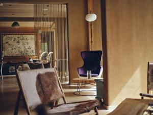 a living room with a chair and a table at Boutique hotel Vila Planinka in Zgornje Jezersko