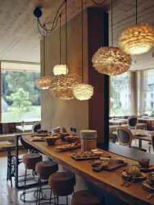 a dining room with a table and chairs and lights at Boutique hotel Vila Planinka in Zgornje Jezersko