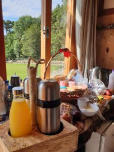 a kitchen counter with some food and orange juice at Chales Manaca da Serra in Urubici