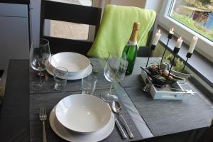 a table with plates and glasses and a bottle of wine at Fewo Traumblick in Kreuzwertheim