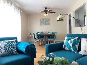 a living room with a blue couch and a table at @ Marbella Lane - 3BR Stylish House near SF in Daly City