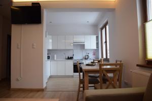 a kitchen and dining room with a table and chairs at Apartament Sienkiewicza 8 in Zamość