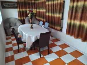 - une table à manger avec un vase de fleurs dans l'établissement Casa Leny, à Călăraşi