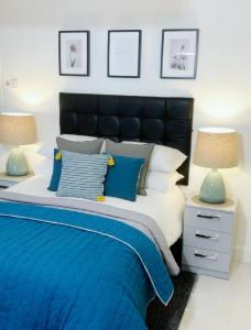 a bedroom with a blue and white bed with two lamps at Anson Studios Walsall M6, J10 in Walsall