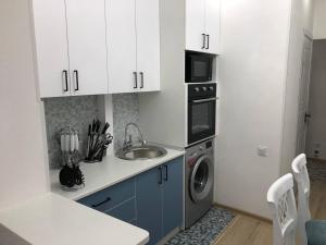 een keuken met een wastafel en een wasmachine bij NEST FOR REST in Tasjkent