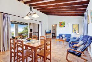 ビニベカにあるSonrisa Binibeca Menorcaのリビングルーム(テーブル、青いソファ付)