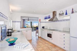 a kitchen with white cabinets and a counter top at Sonrisa Binibeca Menorca in Binibeca