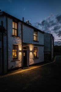 una casa con luces en las ventanas de una calle en The Den - The White House Windermere, en Bowness-on-Windermere