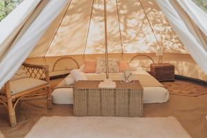 ein Zelt mit einem Bett, einem Stuhl und einem Tisch in der Unterkunft Cocooning Tipi - Seignosse in Seignosse